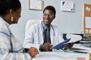 Smiling black doctor consulting female doctor in clinic